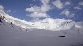 Snow-covered bergen op de achtergrond van wolken en blauwe hemel van een autoraam De Kaukasus, Georgië stock footage Snow-covered bergen op de achtergrond van wolken en blauwe hemel van een autoraam De Kaukasus, Georgië stock footage