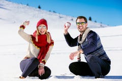 Snowball fight. Winter couple having fun playing in snow outdoors. Young joyful happy multi-racial couple. royalty free stock photos Snowball fight. Winter couple having fun playing in snow outdoors. Young joyful happy multi-racial couple. royalty free stock photos