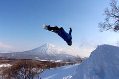 Snowboarder sending it off backcountry jump