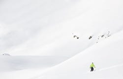 Snowboarderen går sluttande i insnöat nytt pulver en vintermontering royaltyfri fotografi Snowboarderen går sluttande i insnöat nytt pulver en vintermontering royaltyfri fotografi