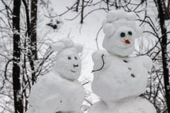 Snowmen couple in the winter forest. Made by hand. Close up stock photo Snowmen couple in the winter forest. Made by hand. Close up stock photo