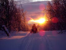 Snowmobile on track at sunset Snowmobile on track at sunset