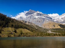 Snowy mountain peak behind an alpine lake. Snowy mountain peak behind an alpine lake in canton of Valais, Switzerland Stock Image Snowy mountain peak behind an alpine lake. Snowy mountain peak behind an alpine lake in canton of Valais, Switzerland Stock Image