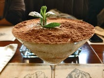 Sobremesa doce do tiramisu da elegância com a hortelã no vidro de martini imagem de stock Sobremesa doce do tiramisu da elegância com a hortelã no vidro de martini imagem de stock
