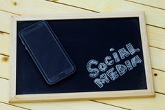 Social media concept with smartphone and word SOCIAL MEDIA written on blackboard Royalty Free Stock Image Social media concept with smartphone and word SOCIAL MEDIA written on blackboard Royalty Free Stock Image