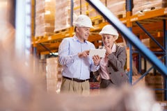 Socios comerciales positivos que miran la pantalla de la tableta imágenes de archivo libres de regalías Socios comerciales positivos que miran la pantalla de la tableta imágenes de archivo libres de regalías