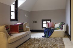 Sofà e sciarpa di svago nella camera da letto della soffitta immagine stock libera da diritti Sofà e sciarpa di svago nella camera da letto della soffitta immagine stock libera da diritti