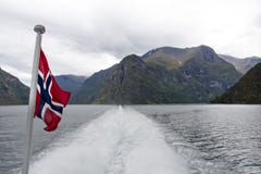 Sognefjord landscape in western Norway with flag and ferry wake stock photography Sognefjord landscape in western Norway with flag and ferry wake stock photography