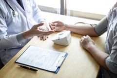 Soignez utilisant un patient de mesure de vérification de tension artérielle présentant l'examen, en présentant le symptôme de ré image libre de droits Soignez utilisant un patient de mesure de vérification de tension artérielle présentant l'examen, en présentant le symptôme de ré image libre de droits