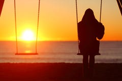 Sola mujer que se sienta en un oscilación que comtempla puesta del sol imágenes de archivo libres de regalías Sola mujer que se sienta en un oscilación que comtempla puesta del sol imágenes de archivo libres de regalías
