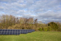 Solar panels in field with trees and cloudy sky royalty free stock images Solar panels in field with trees and cloudy sky royalty free stock images
