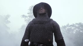 Soldado medieval en armadura del chainmail y con un casco en su cabeza bajo la lluvia almacen de video Soldado medieval en armadura del chainmail y con un casco en su cabeza bajo la lluvia almacen de video