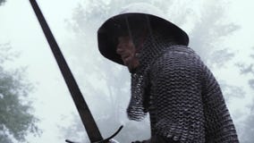 Soldado medieval que lucha en la armadura y el casco del chainmail, balanceando su espada almacen de video Soldado medieval que lucha en la armadura y el casco del chainmail, balanceando su espada almacen de video