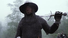 Soldaten i chainmailharnesk med ett svärd på hans skuldra ser omkring arkivfilmer Soldaten i chainmailharnesk med ett svärd på hans skuldra ser omkring arkivfilmer