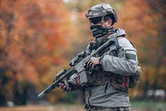 Soldato in armatura e casco che tiene un fucile fotografia stock libera da diritti Soldato in armatura e casco che tiene un fucile fotografia stock libera da diritti