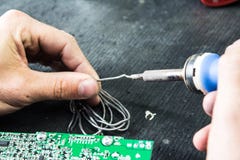 Soldering iron and solder in the hands of a man royalty free stock photo Soldering iron and solder in the hands of a man royalty free stock photo