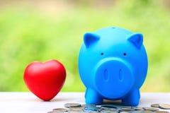 Soldi di risparmio per l'amante o la famiglia e preparare nel concetto futuro, porcellino salvadanaio blu con cuore rosso su fond fotografia stock libera da diritti Soldi di risparmio per l'amante o la famiglia e preparare nel concetto futuro, porcellino salvadanaio blu con cuore rosso su fond fotografia stock libera da diritti