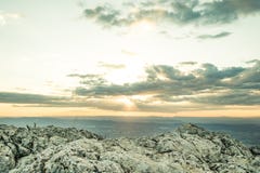Solnedgången på ett berg med vaggar i förgrunden royaltyfri bild Solnedgången på ett berg med vaggar i förgrunden royaltyfri bild