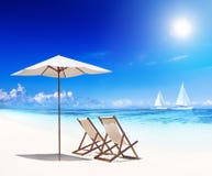 Solstolar på stranden med sikt av seglar fartyg Arkivbilder Solstolar på stranden med sikt av seglar fartyg Arkivbilder
