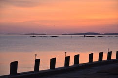 Soluppgång över havet med konturn av pir royaltyfri bild Soluppgång över havet med konturn av pir royaltyfri bild