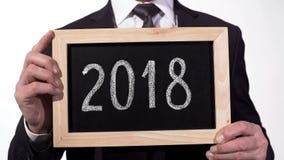 2018 som är skriftlig på svart tavla i affärsmanhänder, årsrapport, motivation arkivfoto 2018 som är skriftlig på svart tavla i affärsmanhänder, årsrapport, motivation arkivfoto