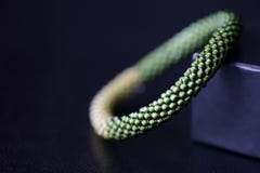 Sombras moldeadas hechas a mano de la pulsera dos del verde en un fondo oscuro imagen de archivo Sombras moldeadas hechas a mano de la pulsera dos del verde en un fondo oscuro imagen de archivo