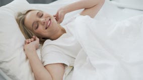 Sommeil sain sur le matelas orthopédique, adolescente heureuse se réveillant avec le sourire Sommeil sain sur le matelas orthopédique, adolescente heureuse se réveillant avec le sourire
