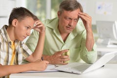 Son and father using laptop at home stock photography Son and father using laptop at home stock photography