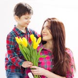 Son hugging his mother and gives her flowers royalty free stock photo Son hugging his mother and gives her flowers royalty free stock photo