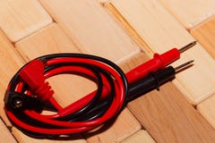 Sonde di un multimetro digitale sul pavimento delle plance di legno fotografia stock Sonde di un multimetro digitale sul pavimento delle plance di legno fotografia stock