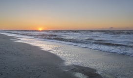 Sonnenaufgang auf einem kalten Strandmeer Lizenzfreie Stockfotos Sonnenaufgang auf einem kalten Strandmeer Lizenzfreie Stockfotos