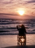 Sonnenuntergang, macht Besichtigung auf dem Strand eine Frau auf Rollstuhl Lizenzfreie Stockbilder Sonnenuntergang, macht Besichtigung auf dem Strand eine Frau auf Rollstuhl Lizenzfreie Stockbilder