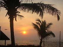 Sonnenuntergang am Promenaden-Strand mit Kokosnuss-Bäumen und Hütte, Pondicherry, Indien stockbilder Sonnenuntergang am Promenaden-Strand mit Kokosnuss-Bäumen und Hütte, Pondicherry, Indien stockbilder
