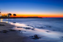 Sonnenuntergang über dem Meer und der Welle, die herauf den Strand sich waschen Stockfotografie Sonnenuntergang über dem Meer und der Welle, die herauf den Strand sich waschen Stockfotografie