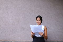 Sonrisa bonita de la muchacha, presentación, papel de los controles en manos y mirada del aw Imagen de archivo libre de regalías