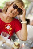 Sonrisa rubia de una más vieja mujer, llevando una camisa roja fotos de archivo Sonrisa rubia de una más vieja mujer, llevando una camisa roja fotos de archivo