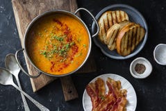 Sopa de lentilha fumado da paprika com os sanduíches grelhados do queijo e bacon friável em um fundo escuro, vista superior Alime imagem de stock Sopa de lentilha fumado da paprika com os sanduíches grelhados do queijo e bacon friável em um fundo escuro, vista superior Alime imagem de stock