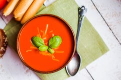 Sopa de Tomatoe com varas de pão e manjericão no fundo de madeira imagem de stock Sopa de Tomatoe com varas de pão e manjericão no fundo de madeira imagem de stock