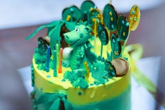 Sophisticatedly ontwierp eigengemaakte Verjaardagscake met Dinosauruscijfer tussen de schatten, de groene en gele kleuren stock foto Sophisticatedly ontwierp eigengemaakte Verjaardagscake met Dinosauruscijfer tussen de schatten, de groene en gele kleuren stock foto