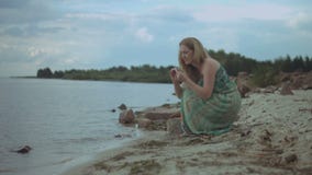 Sorglose Frau, die Seesteine auf dem Strand sammelt stock footage Sorglose Frau, die Seesteine auf dem Strand sammelt stock footage