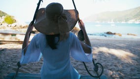 Sorglose glückliche Frau im Hut auf Schwingen am schönen Paradiesstrand in Thailand stock video Sorglose glückliche Frau im Hut auf Schwingen am schönen Paradiesstrand in Thailand stock video