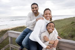Sorridere della famiglia del African-American, abbracciante alla spiaggia immagini stock Sorridere della famiglia del African-American, abbracciante alla spiaggia immagini stock