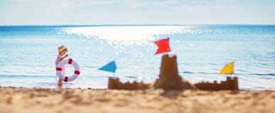 Sorridere di seduta del ragazzo alla spiaggia fotografie stock libere da diritti Sorridere di seduta del ragazzo alla spiaggia fotografie stock libere da diritti