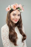 Sorriso bonito da jovem mulher A menina modelo bonita com pele clara, o penteado encaracolado longo e as flores coroam fotografia de stock Sorriso bonito da jovem mulher A menina modelo bonita com pele clara, o penteado encaracolado longo e as flores coroam fotografia de stock