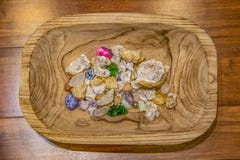 Sortiment av kristaller och stenar av olika färger och texturer i ett snidit träbunkesammanträde på en wood plankayttersida - öve royaltyfri foto Sortiment av kristaller och stenar av olika färger och texturer i ett snidit träbunkesammanträde på en wood plankayttersida - öve royaltyfri foto