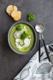 Soupe avec le brocoli et la crème et la cuillère sur le fond gris photographie stock libre de droits Soupe avec le brocoli et la crème et la cuillère sur le fond gris photographie stock libre de droits