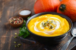 Soupe crème à potiron avec des graines de crème et de citrouille sur la table en bois rustique Photographie stock Soupe crème à potiron avec des graines de crème et de citrouille sur la table en bois rustique Photographie stock