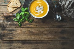 Soupe crème à potiron dans la cuvette avec le basilic et les épices frais Photos stock Soupe crème à potiron dans la cuvette avec le basilic et les épices frais Photos stock