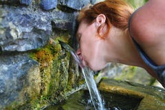 Source of spring water woman drinking