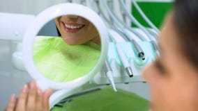 Sourire blanc comme neige reflété dans le miroir après l'art dentaire esthétique de placement de mastic images libres de droits Sourire blanc comme neige reflété dans le miroir après l'art dentaire esthétique de placement de mastic images libres de droits